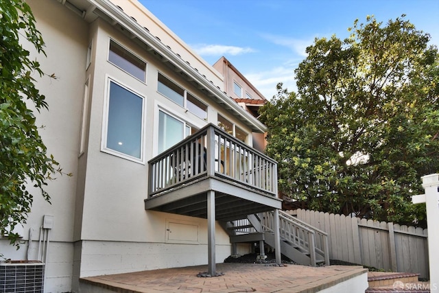 view of side of property with fence, stairs, stucco siding, cooling unit, and a patio area