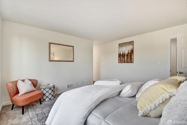 bedroom featuring visible vents, light colored carpet, and baseboards