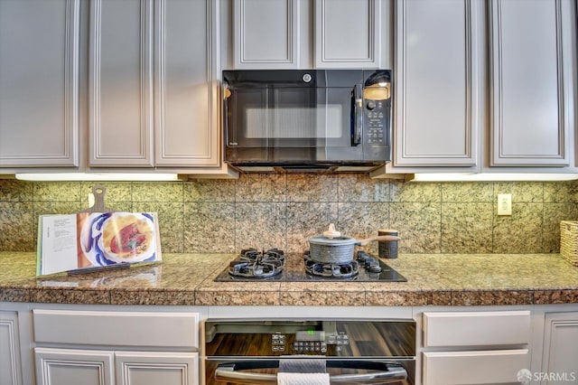 kitchen with white cabinetry, black appliances, tile counters, and tasteful backsplash