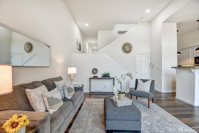 living area featuring dark wood finished floors, visible vents, recessed lighting, and baseboards