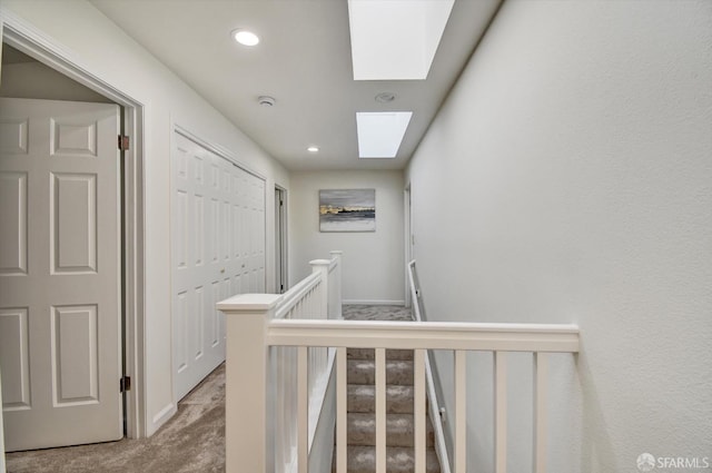 hallway featuring recessed lighting, an upstairs landing, carpet floors, and a skylight