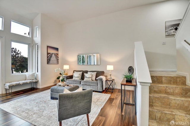 living room featuring stairway, baseboards, and hardwood / wood-style floors