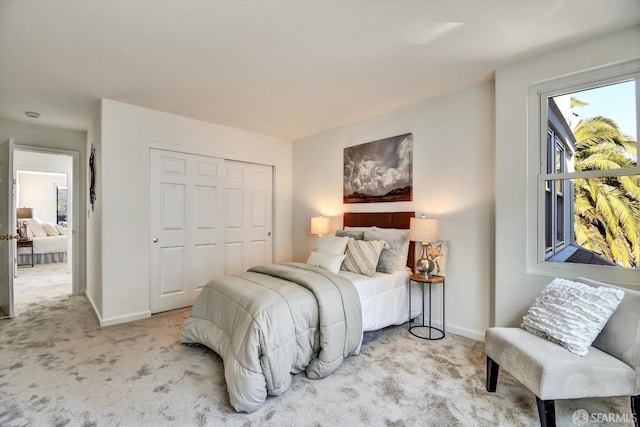 carpeted bedroom featuring baseboards and a closet