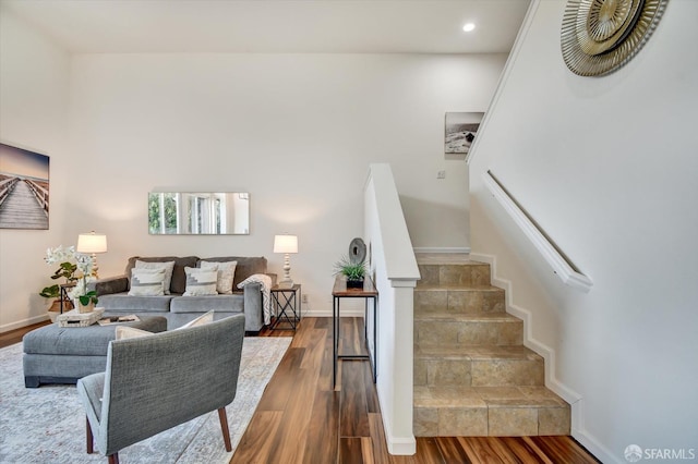 living room with recessed lighting, stairway, baseboards, and wood finished floors