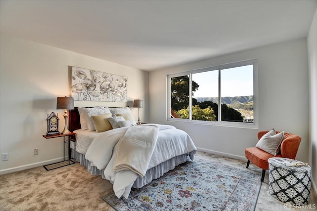 bedroom featuring baseboards, light carpet, and a mountain view