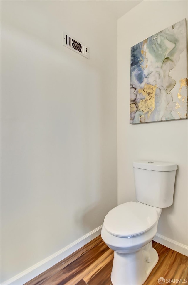 bathroom featuring visible vents, toilet, wood finished floors, and baseboards