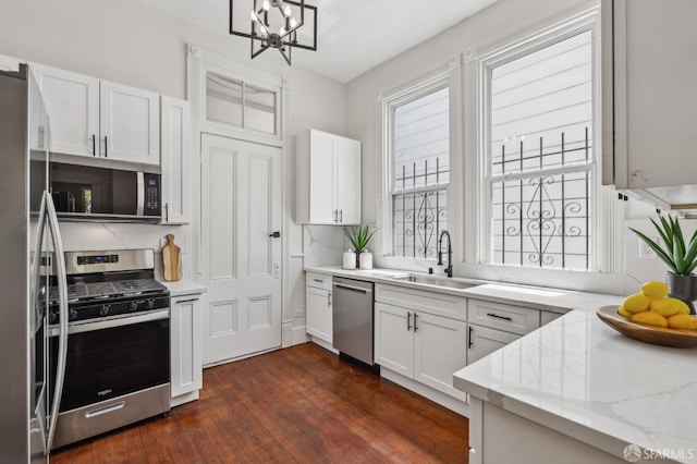 432 Buchanan St, San Francisco, CA 94102 - kitchen with appliances with stainless steel finishes, a sink, dark wood-style floors, a chandelier, and white cabinetry