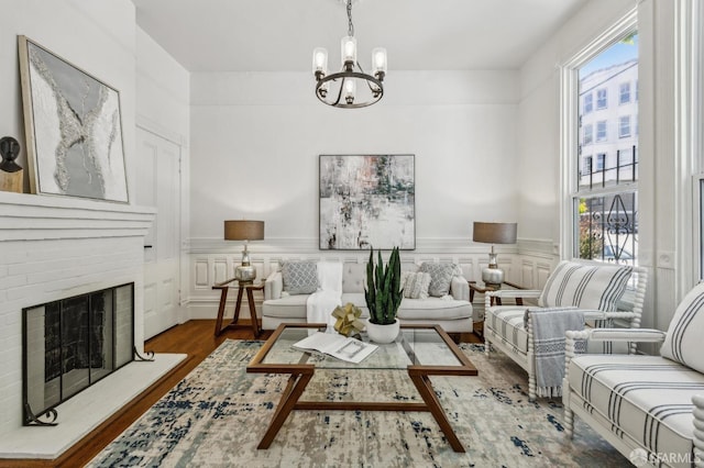 432 Buchanan St, San Francisco, CA 94102 - living room featuring a chandelier, plenty of natural light, wood finished floors, a brick fireplace, and wainscoting