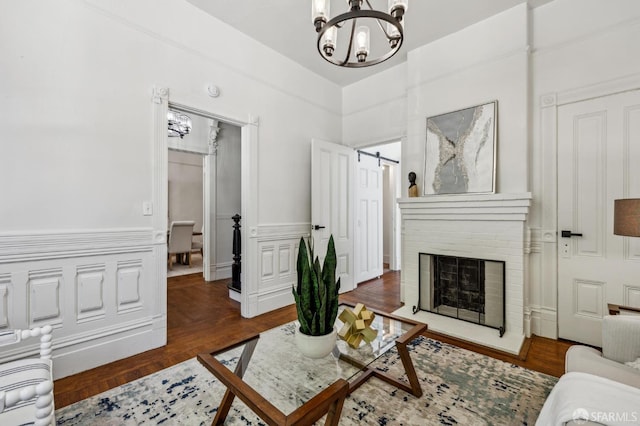 432 Buchanan St, San Francisco, CA 94102 - living area featuring a chandelier, a wainscoted wall, a brick fireplace, wood finished floors, and a decorative wall