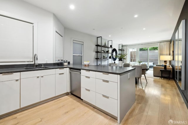 kitchen featuring light hardwood / wood-style flooring, white cabinets, sink, and stainless steel dishwasher