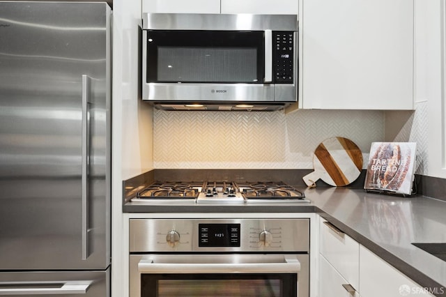 kitchen featuring backsplash, white cabinets, and appliances with stainless steel finishes