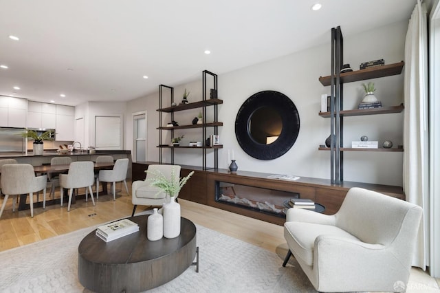 living room featuring light wood-type flooring and sink