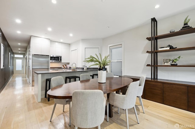 dining area with light wood-type flooring and sink