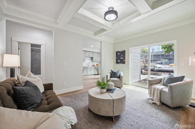 living room with hardwood / wood-style floors, coffered ceiling, beamed ceiling, ornamental molding, and sink