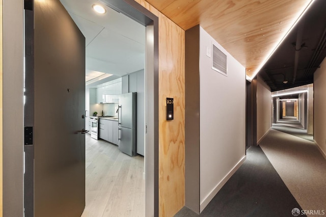 corridor with light hardwood / wood-style flooring