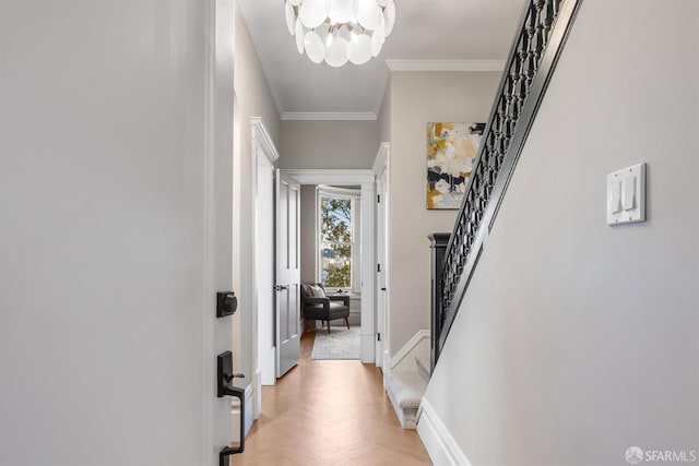 corridor with a notable chandelier, crown molding, stairway, and baseboards