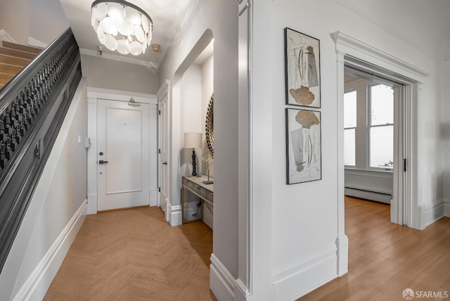 hallway with a chandelier, parquet flooring, baseboards, baseboard heating, and crown molding