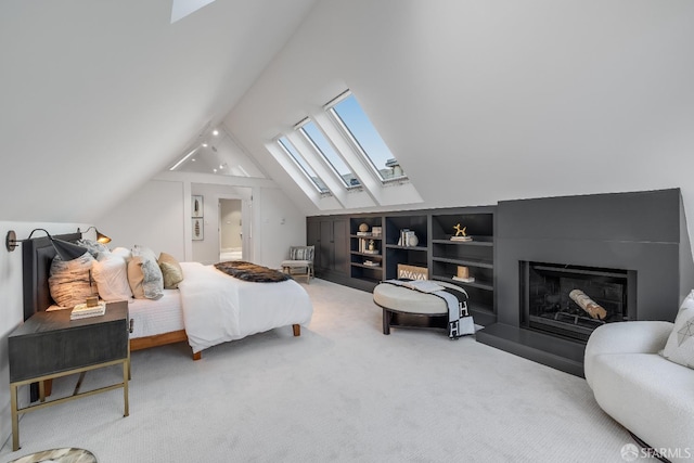 carpeted bedroom with vaulted ceiling with skylight and a fireplace with raised hearth