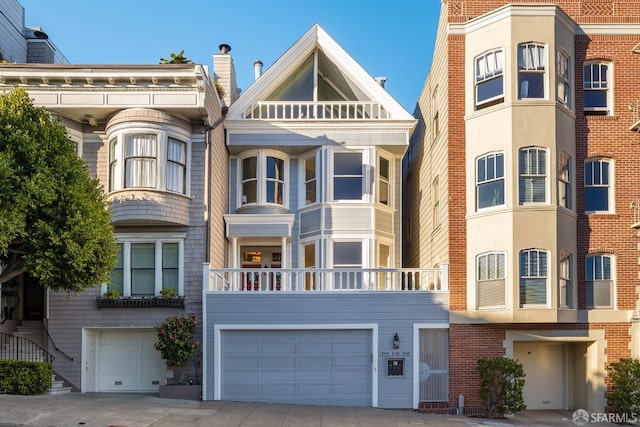 view of front of house with driveway, a balcony, and an attached garage