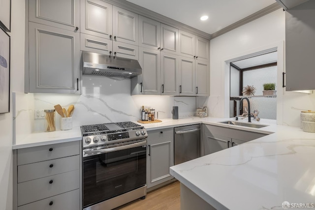 kitchen featuring appliances with stainless steel finishes, gray cabinets, a sink, and under cabinet range hood