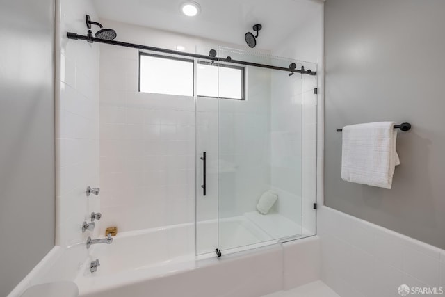 bathroom with bath / shower combo with glass door