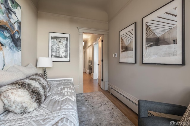 interior space with a baseboard radiator, baseboards, and wood finished floors