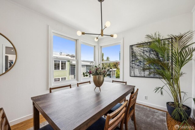 221 Lily St, San Francisco, CA 94102 - dining room featuring a chandelier, baseboards, and wood finished floors