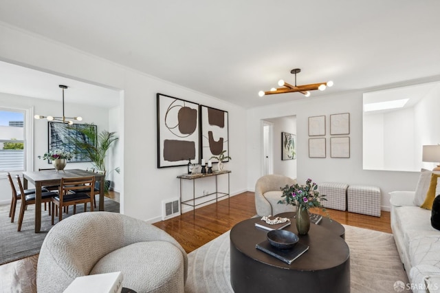 221 Lily St, San Francisco, CA 94102 - living room featuring a chandelier, wood finished floors, and baseboards