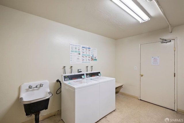 common laundry area with light floors, independent washer and dryer, and a sink