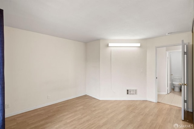 unfurnished room with light wood-style floors, visible vents, and baseboards