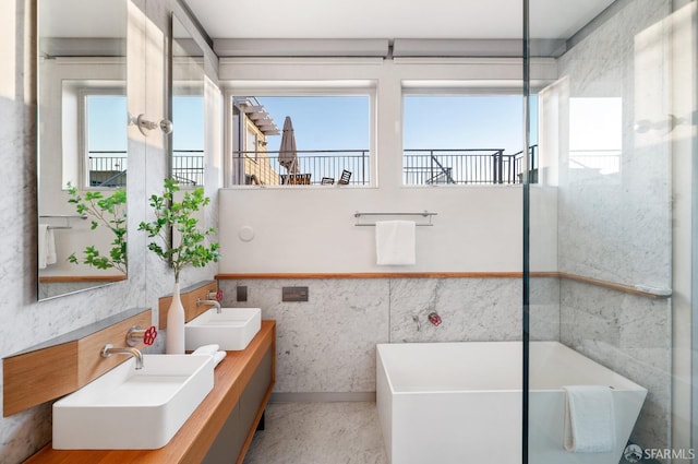 bathroom featuring a bathtub, a healthy amount of sunlight, and vanity