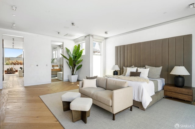 bedroom featuring light hardwood / wood-style flooring and multiple windows