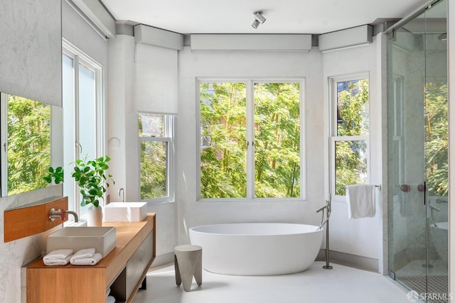 bathroom with vanity, separate shower and tub, concrete flooring, and plenty of natural light