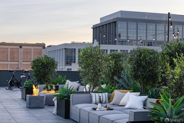 patio terrace at dusk featuring an outdoor living space with a fire pit