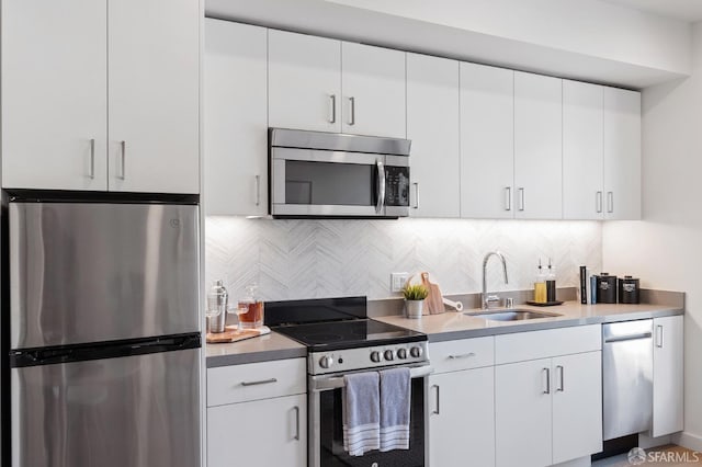 kitchen featuring a sink, light countertops, backsplash, and stainless steel appliances