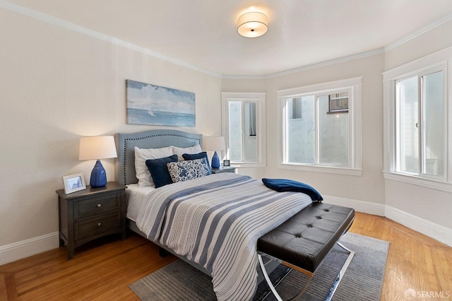 bedroom with crown molding and light hardwood / wood-style flooring