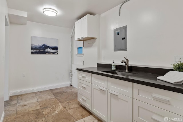 kitchen featuring sink, white cabinets, and electric panel