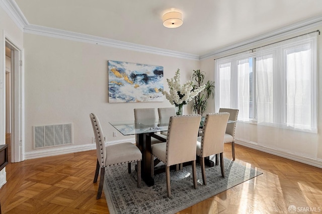 dining space with light parquet flooring and crown molding