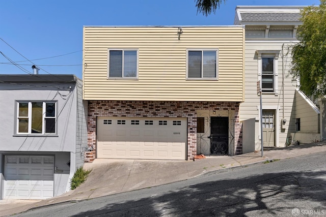 341 Prentiss St, San Francisco, CA 94110 - view of front facade featuring an attached garage, brick siding, and driveway