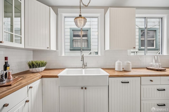 1371-1373 16th Ave, San Francisco, CA 94122 - kitchen featuring wood counters, backsplash, glass insert cabinets, and white cabinets