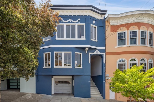 1371-1373 16th Ave, San Francisco, CA 94122 - view of front of property featuring stucco siding, an attached garage, stairs, and driveway