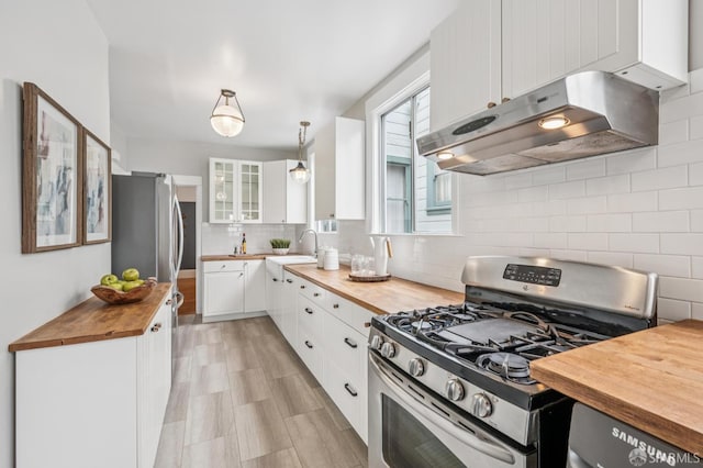 1371-1373 16th Ave, San Francisco, CA 94122 - kitchen with appliances with stainless steel finishes, wooden counters, exhaust hood, white cabinetry, and glass insert cabinets