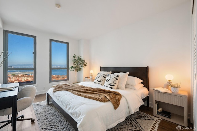 bedroom featuring a water view and wood-type flooring