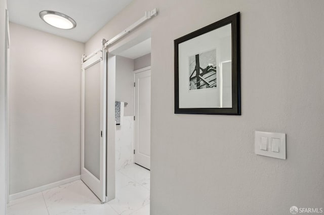 88 King St Unit 104, San Francisco, CA 94107 - hallway featuring a barn door, marble finish floor, and baseboards