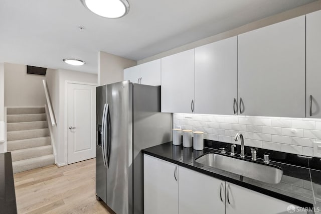 88 King St Unit 104, San Francisco, CA 94107 - kitchen with stainless steel fridge with ice dispenser, tasteful backsplash, a sink, dark countertops, and light wood-style floors