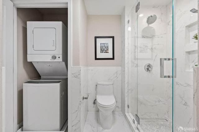 88 King St Unit 104, San Francisco, CA 94107 - bathroom with marble finish floor, toilet, a marble finish shower, stacked washer / dryer, and tile walls