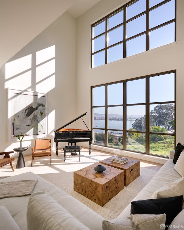 living room featuring a water view and a high ceiling