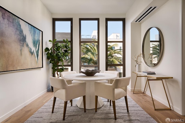 dining space featuring light wood-style flooring and baseboards