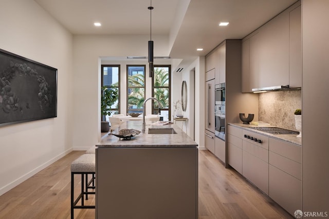 kitchen featuring stainless steel gas stovetop, backsplash, a sink, an island with sink, and modern cabinets