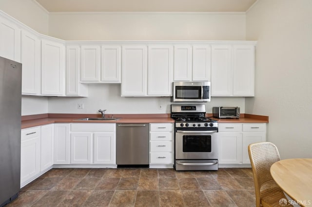 1695 Sutter St, San Francisco, CA 94109 - kitchen with stainless steel appliances, white cabinets, stone finish flooring, and ornamental molding